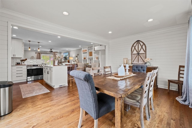 dining room featuring recessed lighting, light wood finished floors, an AC wall unit, and ornamental molding