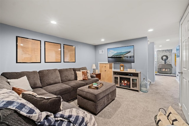 carpeted living room with baseboards, a wood stove, and recessed lighting