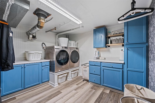 laundry room featuring cabinet space, washing machine and dryer, and light wood-style flooring