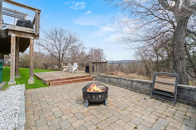view of patio featuring a wooden deck and an outdoor fire pit