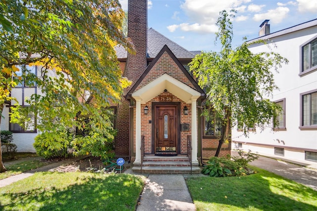 71-38 Harrow St, Forest Hills, NY 11375 - view of front of home with brick siding, a front lawn, and a chimney