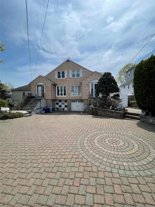 view of front facade featuring an attached garage and curved driveway