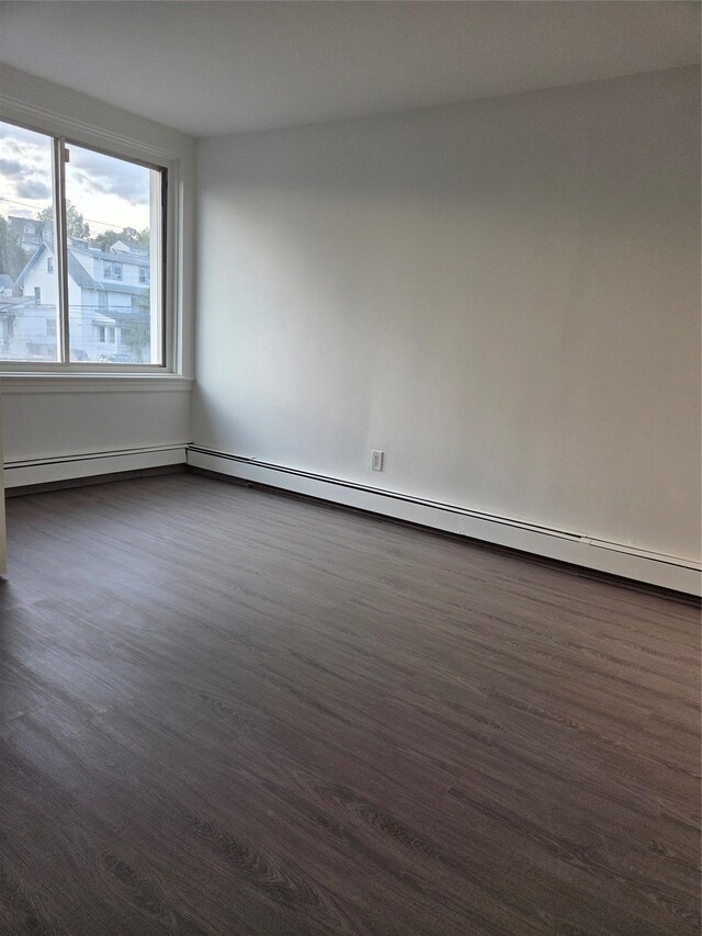111 Washington St, Port Chester, NY 10573 - unfurnished room with dark wood finished floors and a baseboard heating unit