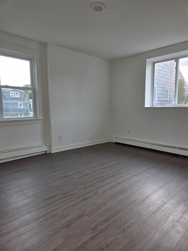 111 Washington St, Port Chester, NY 10573 - unfurnished room featuring a baseboard heating unit, dark wood finished floors, and baseboards