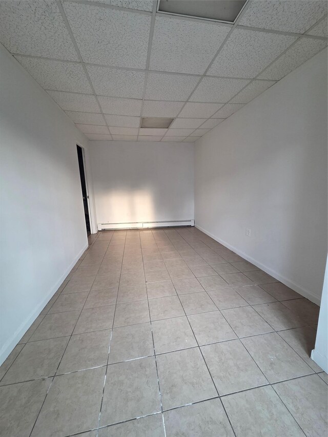 111 Washington St, Port Chester, NY 10573 - unfurnished room featuring a drop ceiling, baseboard heating, light tile patterned floors, and baseboards