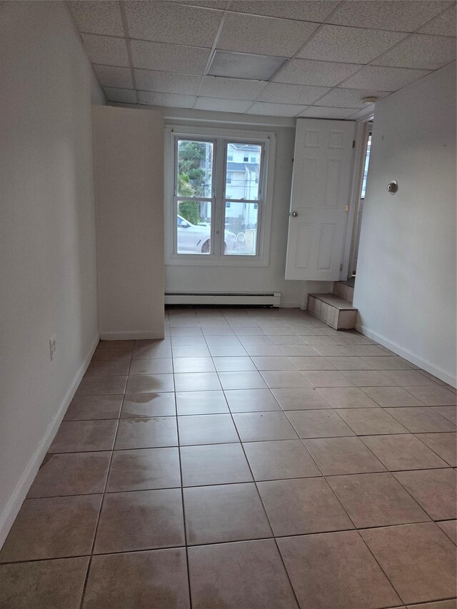 111 Washington St, Port Chester, NY 10573 - spare room featuring baseboard heating, a paneled ceiling, light tile patterned floors, and baseboards