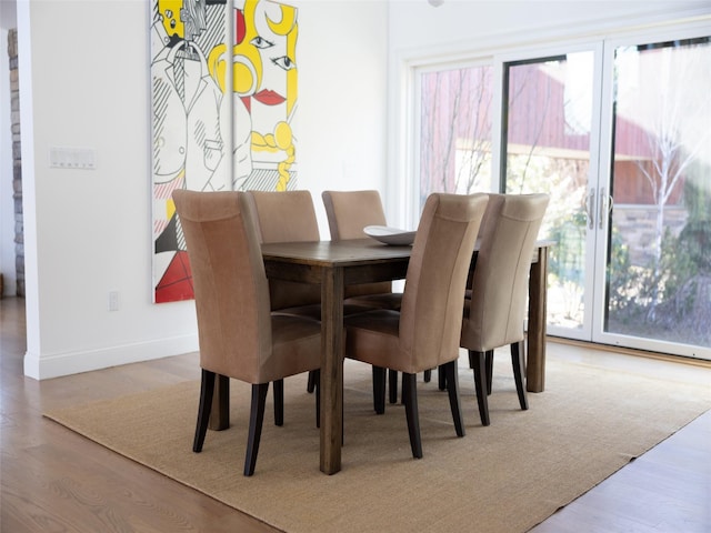 dining space with wood finished floors, baseboards, and a wealth of natural light