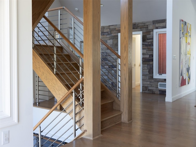stairs featuring wood finished floors, baseboards, and visible vents
