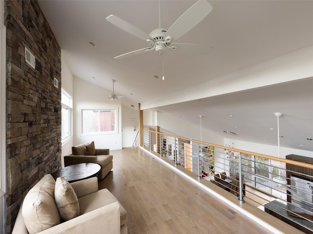 interior space featuring wood finished floors, ceiling fan, visible vents, and high vaulted ceiling