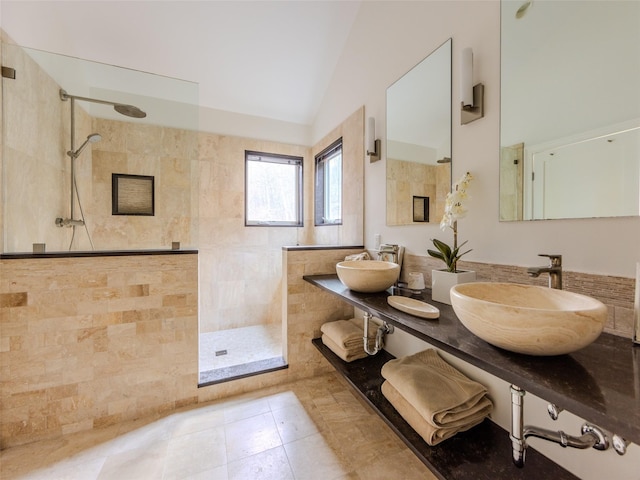 bathroom featuring walk in shower, vaulted ceiling, and a sink