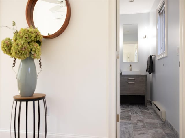 corridor with a baseboard radiator and baseboards