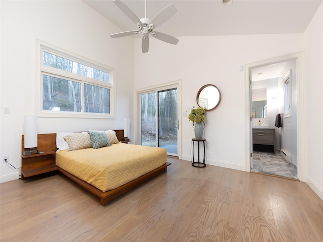 bedroom with access to outside, a baseboard heating unit, baseboards, and light wood-type flooring