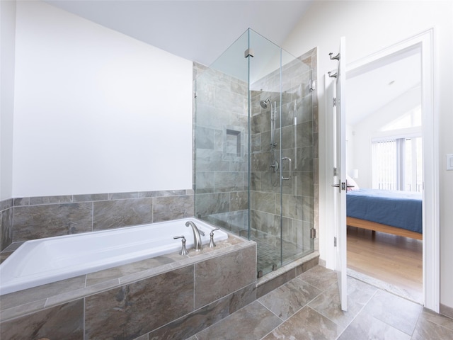ensuite bathroom with lofted ceiling, ensuite bath, a stall shower, and a garden tub