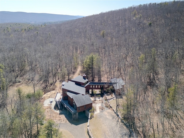 drone / aerial view featuring a mountain view and a view of trees