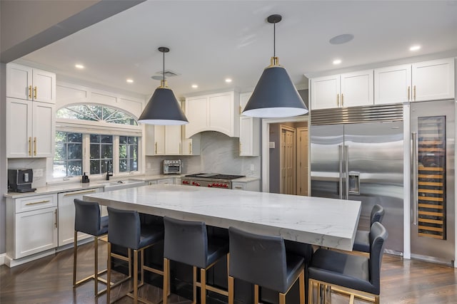 kitchen featuring range, a center island, tasteful backsplash, and white cabinetry
