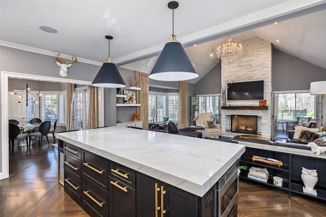 kitchen with open floor plan, dark cabinetry, and a healthy amount of sunlight