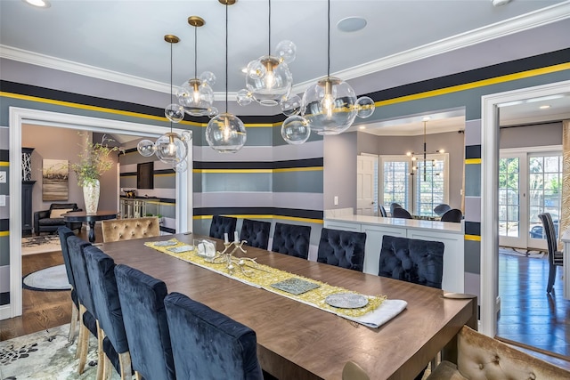 dining room featuring a notable chandelier, crown molding, and wood finished floors