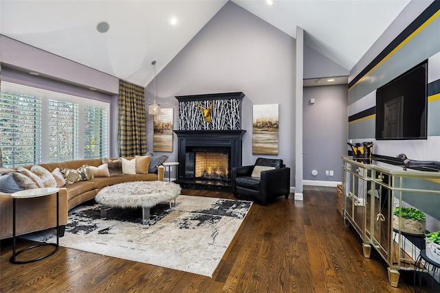 living room featuring high vaulted ceiling, a lit fireplace, baseboards, and dark wood finished floors
