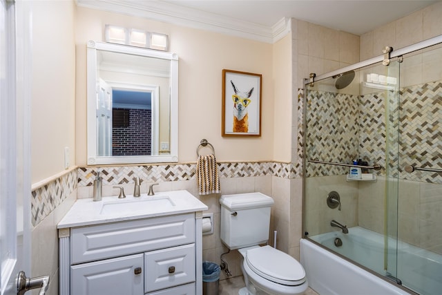 full bathroom featuring combined bath / shower with glass door, ornamental molding, toilet, tile walls, and vanity