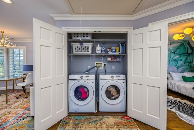 laundry room with laundry area, dark wood-type flooring, ornamental molding, attic access, and washing machine and clothes dryer