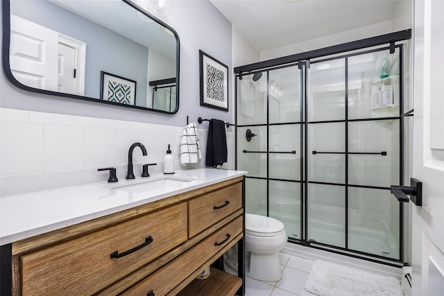 bathroom with a shower stall, tile patterned flooring, vanity, and toilet
