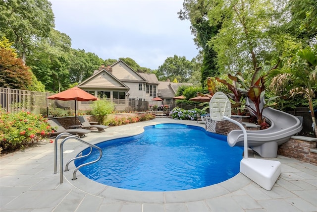 view of pool with a fenced in pool, a patio, a fenced backyard, and a water slide
