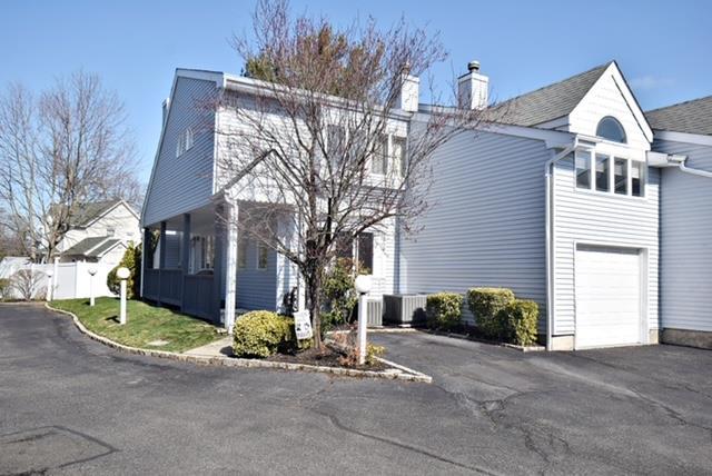 10 Windsor Ct, Amityville, NY 11701 - view of property exterior featuring cooling unit, fence, driveway, a garage, and a chimney
