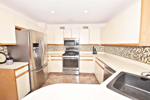 10 Windsor Ct, Amityville, NY 11701 - kitchen featuring a sink, visible vents, stainless steel appliances, and backsplash