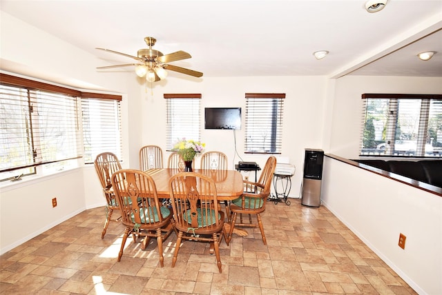 10 Windsor Ct, Amityville, NY 11701 - dining room featuring stone finish flooring, baseboards, and ceiling fan