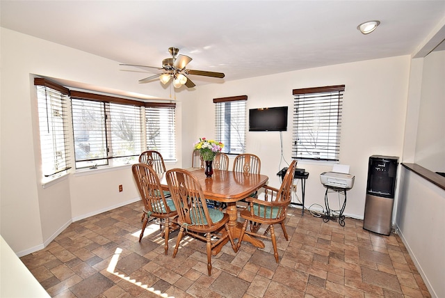 10 Windsor Ct, Amityville, NY 11701 - dining area featuring baseboards, stone finish flooring, and a ceiling fan