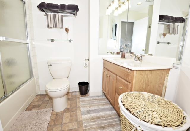 10 Windsor Ct, Amityville, NY 11701 - full bath with toilet, vanity, and shower / bath combination with glass door