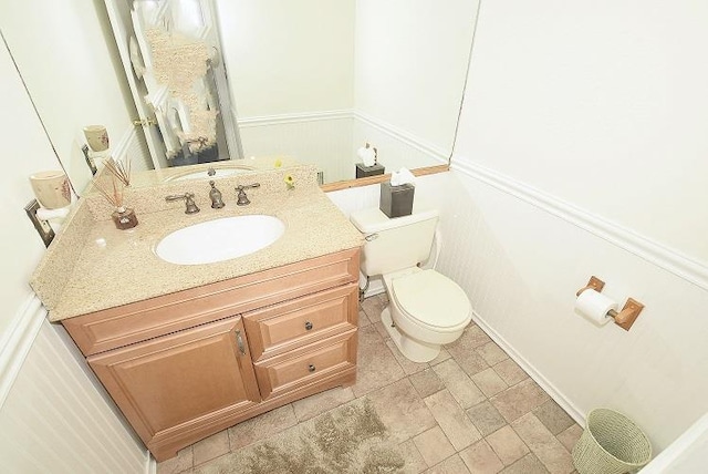 10 Windsor Ct, Amityville, NY 11701 - half bathroom featuring toilet, vanity, and wainscoting