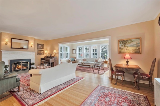 living area featuring a brick fireplace and light wood-style flooring