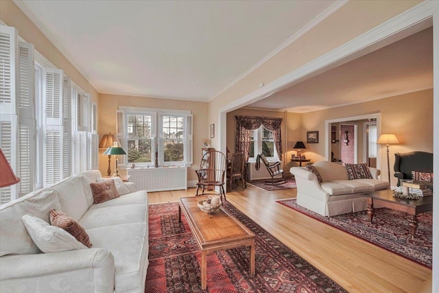 living room with ornamental molding and wood finished floors