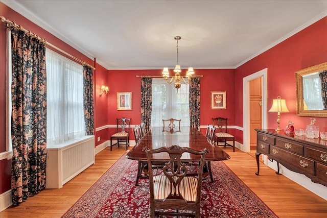 dining room featuring an inviting chandelier, crown molding, and light wood finished floors
