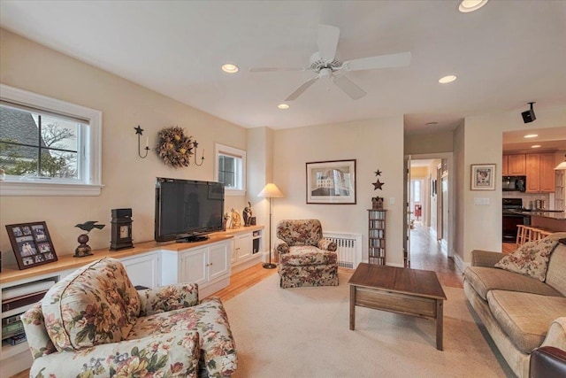 living room with recessed lighting, radiator, ceiling fan, and light carpet