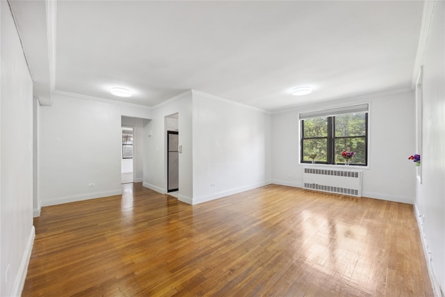 150-10 71st Ave Unit 3L, Flushing, NY 11367 - unfurnished room featuring radiator heating unit, wood-type flooring, baseboards, and crown molding