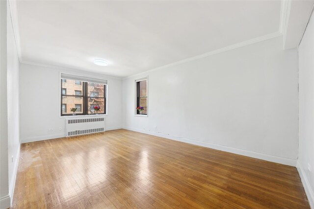150-10 71st Ave Unit 3L, Flushing, NY 11367 - unfurnished room featuring radiator, wood finished floors, crown molding, and baseboards