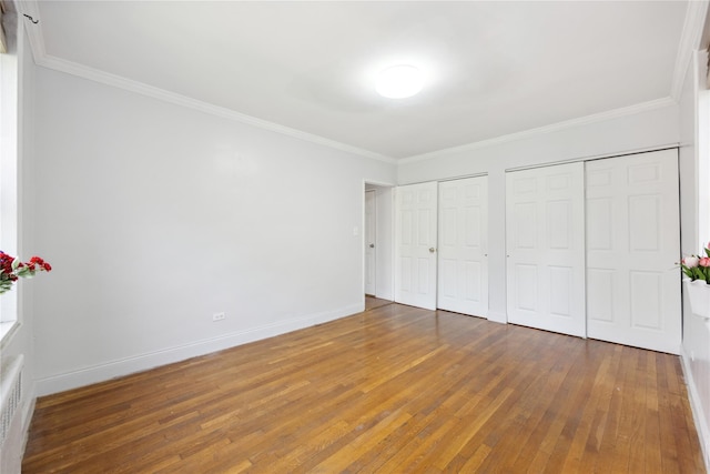 150-10 71st Ave Unit 3L, Flushing, NY 11367 - unfurnished bedroom featuring two closets, crown molding, hardwood / wood-style flooring, and baseboards