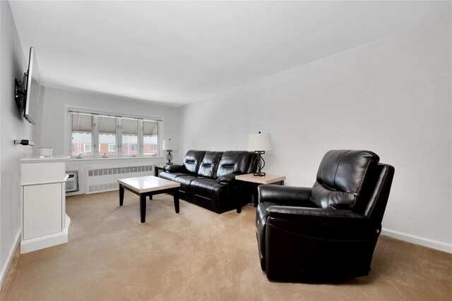 living room with radiator, baseboards, and light colored carpet