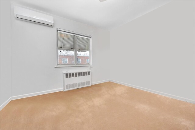 unfurnished room with light colored carpet, a wall mounted air conditioner, radiator heating unit, and baseboards
