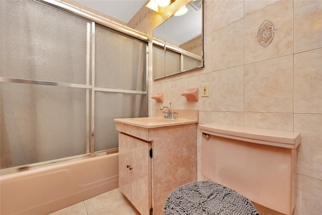 bathroom with vanity, bath / shower combo with glass door, tile patterned flooring, decorative backsplash, and tile walls