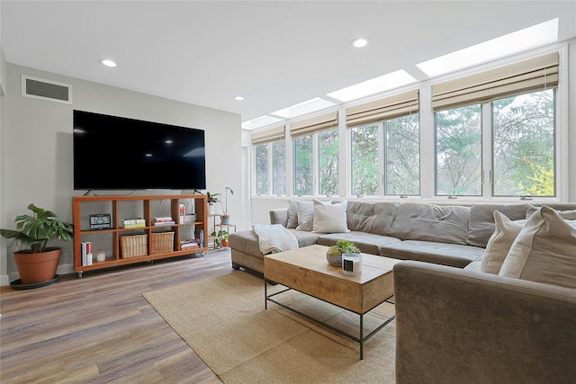 living room with recessed lighting, visible vents, plenty of natural light, and wood finished floors