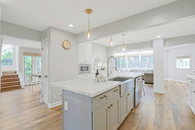 kitchen featuring a sink, appliances with stainless steel finishes, plenty of natural light, and light wood-style flooring