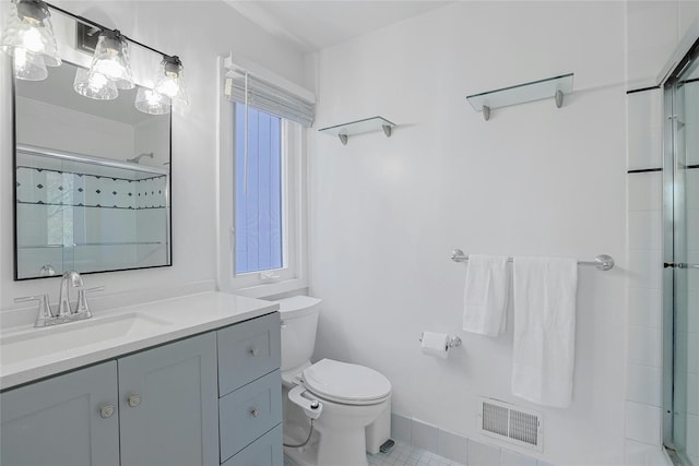 bathroom featuring visible vents, a shower with shower door, vanity, tile patterned floors, and toilet