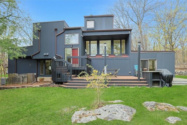 back of property with a lawn and a deck