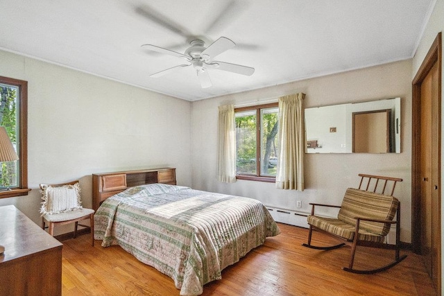 59 Giant Oak Rd, Ridge, NY 11961 - bedroom featuring a baseboard radiator, light wood-style flooring, and ceiling fan