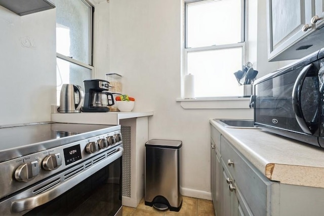1185 E Broadway Unit 4A, Hewlett, NY 11557 - kitchen featuring electric stove, a healthy amount of sunlight, light countertops, and gray cabinets