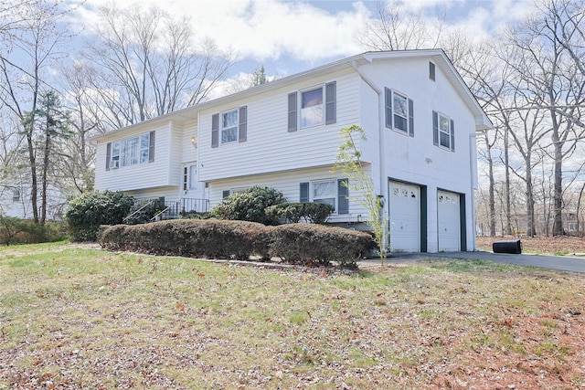 split foyer home featuring an attached garage, driveway, and a front yard