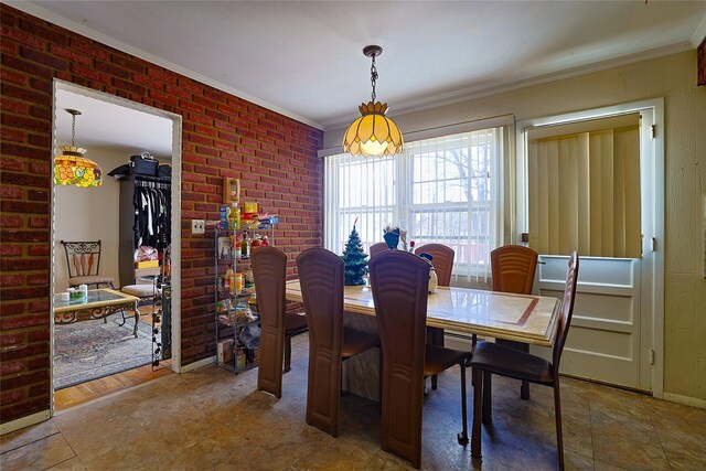 dining space with crown molding and brick wall